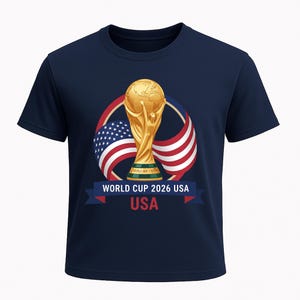 May include: Navy blue t-shirt featuring a gold trophy, the American flag, and the text "WORLD CUP 2026 USA". The design includes a ribbon with the word "USA" in red.