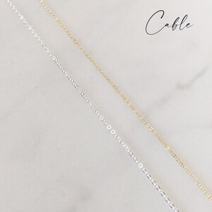 May include: Two cable chains, one silver and one gold, are shown against a white background. The word "Cable" is written in black script at the top of the image.