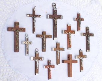 Puede incluir: Una colección de doce crucifijos de madera con figuras de Jesús plateadas. Los crucifijos son de diferentes tamaños y estilos, algunos con detalles ornamentados.
