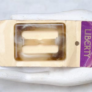 Fivela de cinto de chifre falso da Liberty London em cartão original - Corrediça de celuloide Art Déco - Suprimentos e componentes de alta costura vintage alterados da NOS