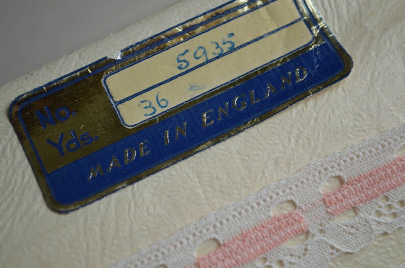 May include: A white label with blue trim and gold lettering. The label reads "No. Yds. 36 5935 MADE IN ENGLAND".