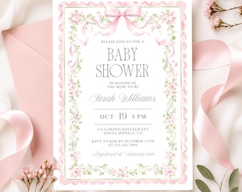 May include: A rectangular baby shower invitation card with a scalloped pink border, featuring a watercolor illustration of pink flowers and a large pink ribbon bow at the top. The text reads: PLEASE JOIN US FOR A BABY SHOWER IN HONOR OF THE MOM-TO-BE Sarah Williams OCT 19 5 PM 123 GARDEN RESTAURANT SANTA MONICA, CA RSVP TO KIM BY OCTOBER 15TH AT 123.456.7890 Registered at Amazon.com