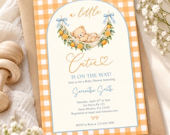 May include: A rectangular baby shower invitation card featuring an orange and white gingham border. The center displays a watercolor illustration of a teddy bear sleeping in a hammock decorated with oranges and white flowers, with the text a little Cutie IS ON THE WAY! honoring Samantha Smith on Saturday, April 25th at 5pm, Joe Davis Dr 123, Santa Monica, CA 12345, registered at target and Amazon.com, RSVP to Kim at 123.456.7890.