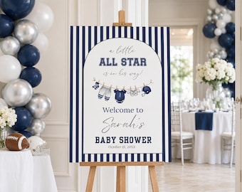 May include: A rectangular baby shower sign on a wooden easel featuring navy blue and white vertical stripes. The center displays an arched design with the text 'a little ALL STAR is on her way!', 'Welcome to Sarah's BABY SHOWER', and 'October 15, 20XX'.