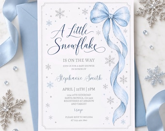 May include: A white rectangular baby shower invitation card featuring a large watercolor light blue ribbon bow, silver snowflake illustrations, and dark blue script text that reads A Little Snowflake Is On The Way, Stephanie Smith.