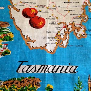May include: A blue and white map of Tasmania, Australia, with red apples and the word "Tasmania" in cursive. The map highlights towns and geographical features with brown outlines and red lines.