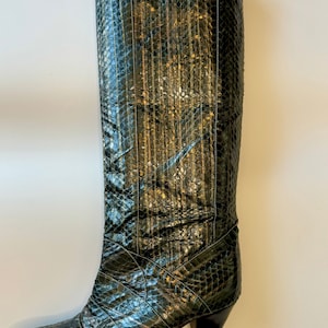 Puede incluir: Botas altas de piel de serpiente verde con punta puntiaguda y tacón de aguja alto.