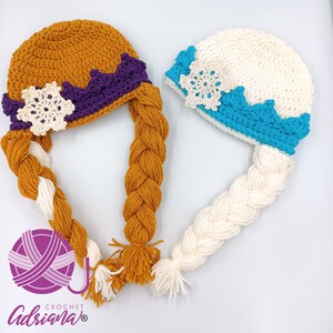 Peut inclure: Deux bonnets en crochet avec des tresses, l'un en blanc et bleu avec un motif de flocon de neige, et l'autre en orange et violet avec un motif de flocon de neige. Les bonnets sont pour enfants et sont faits à la main.