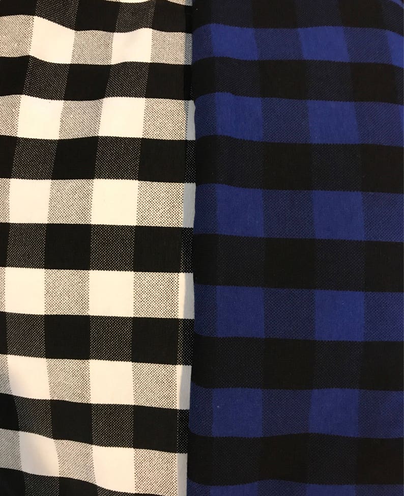 May include: Close-up of two fabrics with a checkered pattern. One fabric is black and white, the other is black and blue. The checkered pattern is made up of large squares.