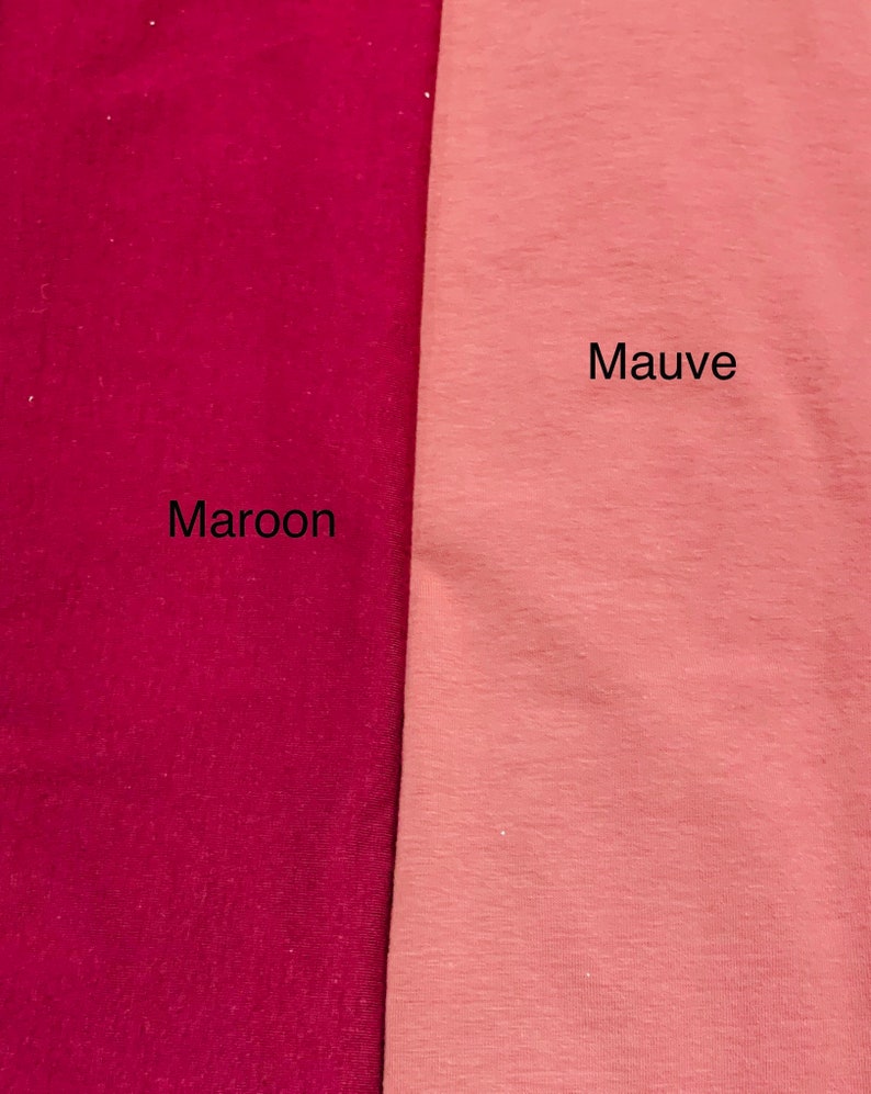 May include: Two fabric swatches, one maroon and one mauve, are displayed side by side. The word "Maroon" is printed below the maroon swatch, and the word "Mauve" is printed below the mauve swatch. The fabrics appear to be a soft knit.
