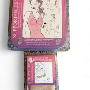 Puede incluir: Dos paquetes de sujetadores adhesivos SUPPORTABLES. El paquete superior es rosa y presenta un dibujo de una mujer con un sujetador sin tirantes. El paquete inferior es beige y presenta un dibujo de una mujer con un sujetador adhesivo.