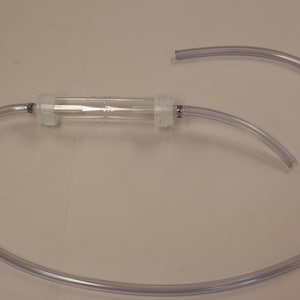 May include: A clear, transparent tube with a cylindrical filter in the center. The tube is connected to clear flexible tubing, forming a circular shape. The filter is held in place by white plastic connectors.
