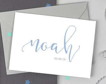 May include: A white card with the name "noah" written in blue cursive script. The date "02.06.19" is written below the name in black.