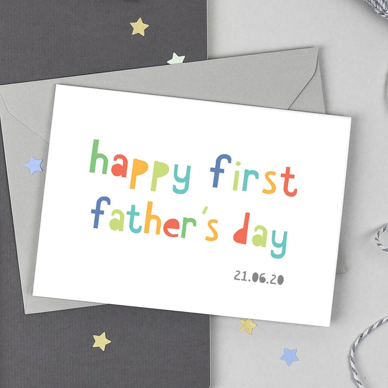 May include: A white card with the text "happy first father's day" in colorful letters. The date "21.06.20" is printed below the text.