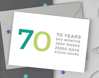 May include: A white greeting card with the number 70 in teal and lime green, with text listing the equivalent time in months, weeks, days, and hours. The card is on a gray envelope, with star-shaped confetti.