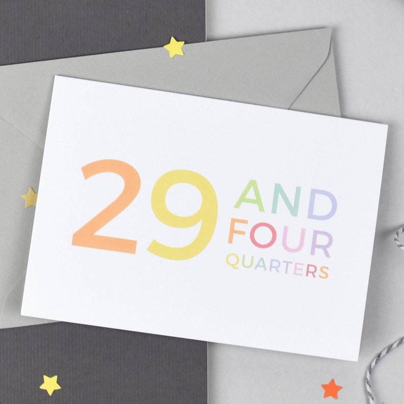 May include: A white card with the number 29 in rainbow colors and the text "AND FOUR QUARTERS" in rainbow colors.