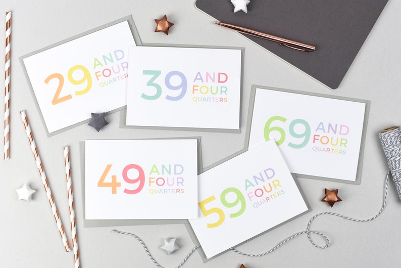 May include: Five greeting cards with a white background and gray borders. Each card features a different number, 29, 39, 49, 59, and 69, with the text "and four quarters" below the number. The numbers are in rainbow colors.