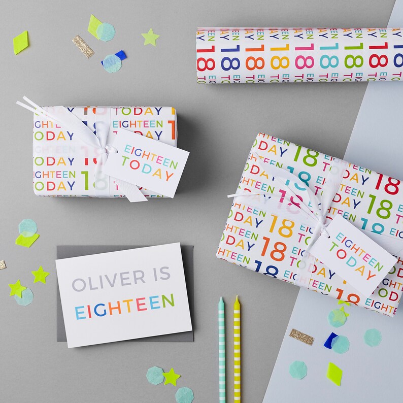 May include: Two wrapped gifts with colorful "Eighteen Today" wrapping paper. A gray card with the text "Oliver is Eighteen" in colorful letters.  Two striped candles and confetti.
