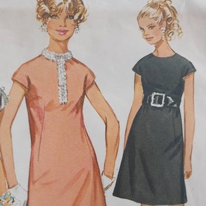 Könnte beinhalten: Zwei Vintage-Kleidermuster mit einem ärmellosen, A-förmigen Kleid mit Rundhalsausschnitt. Das Kleid links ist pfirsichfarben und hat einen Perlenbesatz am Ausschnitt. Das Kleid rechts ist schwarz und hat einen schwarzen Gürtel mit einer silbernen Schnalle.