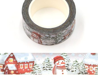 May include: A roll of washi tape with a winter scene featuring a snowman, a red house, and snowflakes on a gray background.