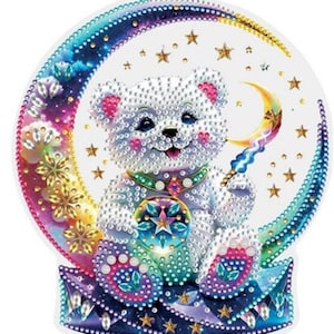 May include: A white bear with a pearl-like finish sits on a crescent moon with a rainbow-colored background. The bear holds a star-shaped object in its paws. The moon is surrounded by stars and a crescent moon with a lightning bolt.