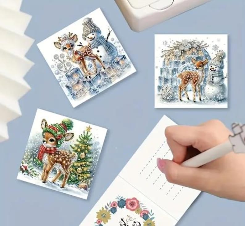 May include: Three Christmas cards featuring a winter scene with a deer and a snowman. The cards are blank inside for writing a message.