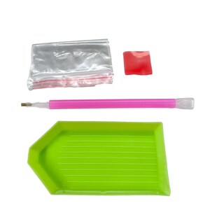 May include: A diamond painting kit with a green tray, pink stylus, red wax square, and a small clear bag. The tray is shaped like a hexagon with a flat bottom and ridged interior. The stylus is pink with a clear tip.
