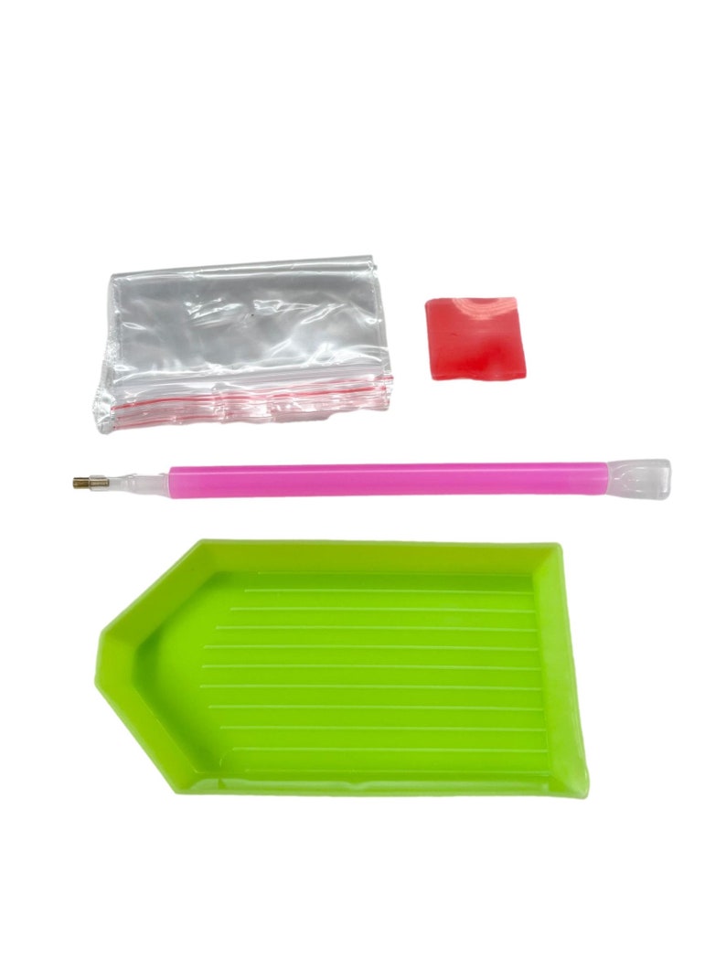 May include: A diamond painting kit with a green tray, pink stylus, red wax square, and a small clear bag. The tray is shaped like a hexagon with a flat bottom and ridged interior. The stylus is pink with a clear tip.
