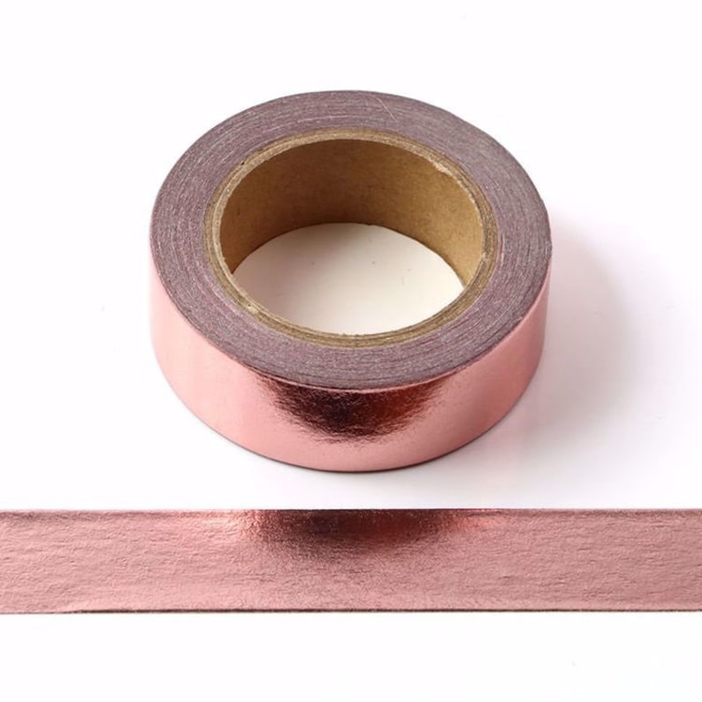 K&ouml;nnte beinhalten: Eine Rolle ros&eacute;goldenes Metallic-Washi-Tape. Das Band ist um einen Pappkern gewickelt und hat eine gl&auml;nzende, metallische Oberfl&auml;che.
