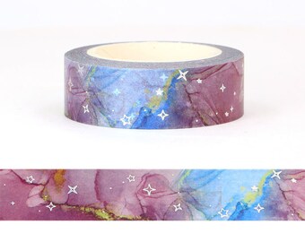May include: A roll of washi tape with a blue and purple watercolor background and silver foil stars.