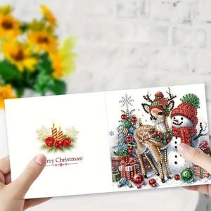 May include: A Christmas card with a festive design featuring a snowman, a deer, and a Christmas tree. The card has the text "Merry Christmas!" printed on it.