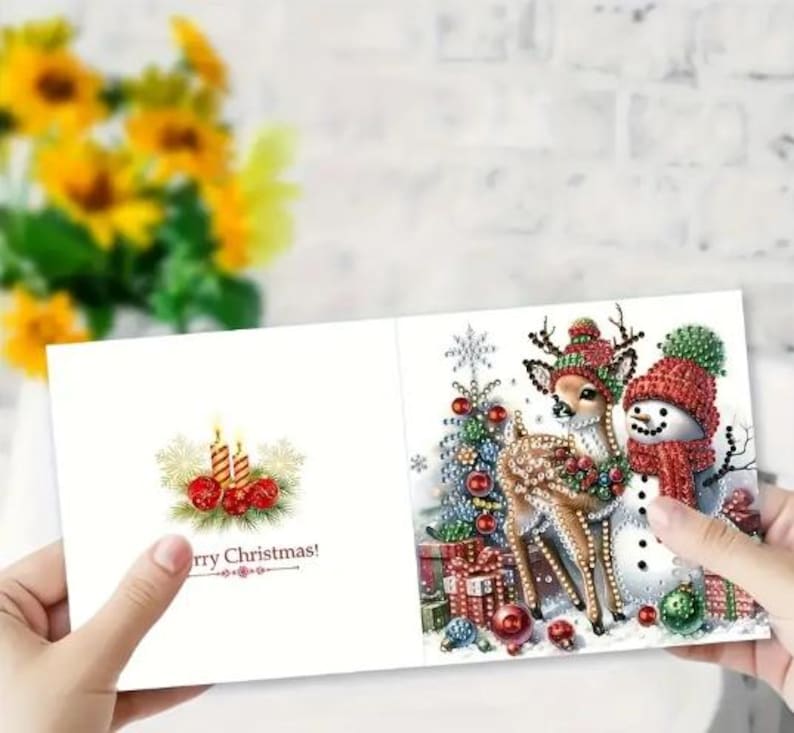 May include: A Christmas card with a festive design featuring a snowman, a deer, and a Christmas tree. The card has the text "Merry Christmas!" printed on it.