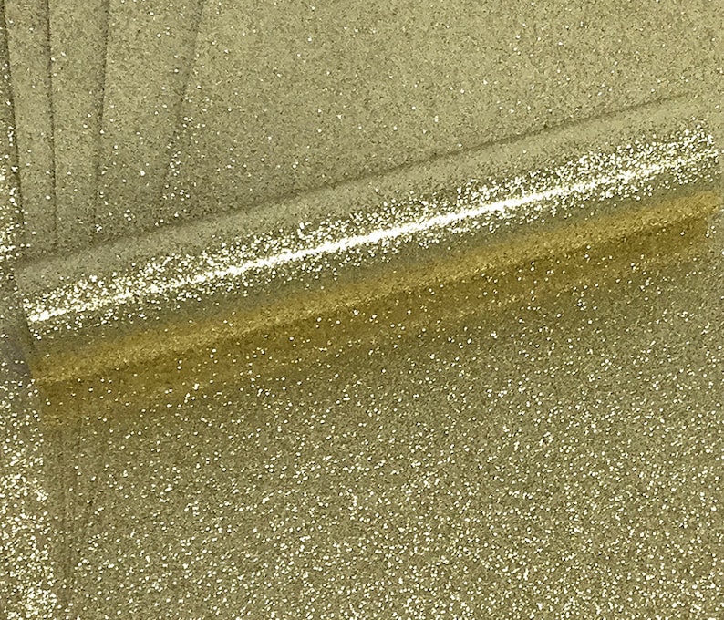 May include: A roll of gold glitter fabric with a fine, sparkly texture.