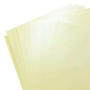 May include: A stack of eight sheets of pale yellow cardstock paper.