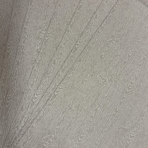 May include: A stack of light gray paper sheets with a wood grain pattern. The design features detailed white lines mimicking the texture of wood, including knots and grain patterns. The sheets are fanned out, showcasing the repeating design.
