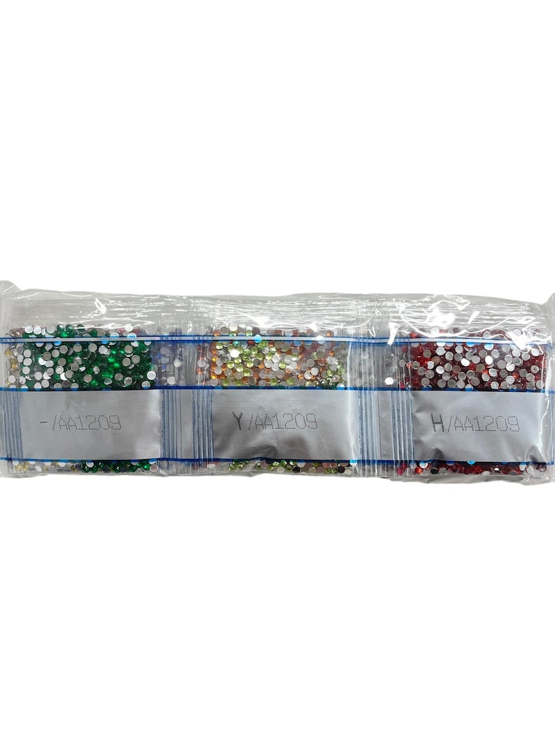 May include: Three small bags of colorful diamond-shaped rhinestones. The bags are labeled with the letters "Y", "H", and "I" followed by the number "AA1209".