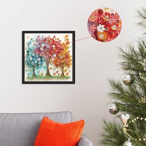 May include: A framed artwork featuring three stylized trees with colorful, paper-like flowers. The trees transition from blue to red to yellow, with intricate details and a black frame. A close-up shows the floral details.
