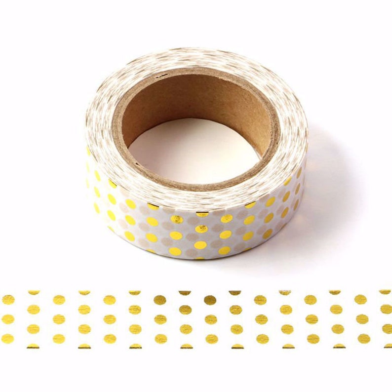 May include: A roll of white washi tape with gold polka dots. The tape is on a white background.