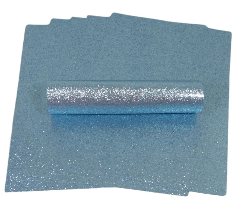 Op de afbeelding: Een rol lichtblauwe glitterstof met een zilveren glans. De stof is opgerold en het einde is zichtbaar.