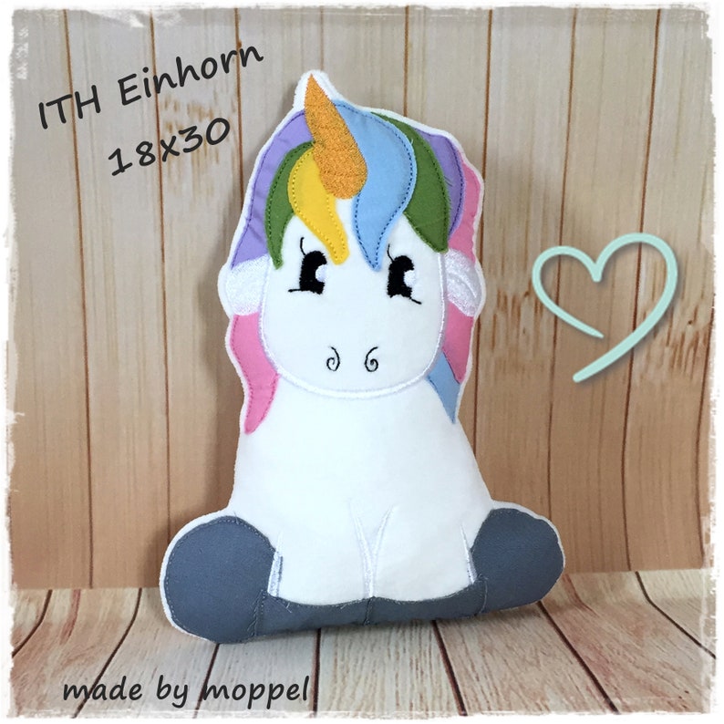 Puede incluir: Un coj&iacute;n de unicornio de peluche con cuerpo blanco, melena colorida y cuerno dorado. El coj&iacute;n mide aproximadamente 46 x 76 cm. El texto "ITH Einhorn" y "made by moppel" son visibles.