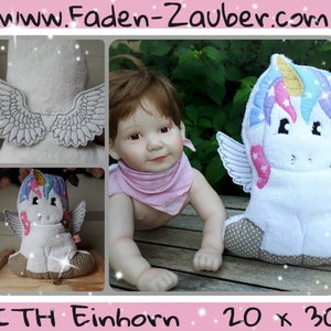 May include: White unicorn-shaped hooded towel with embroidered details, including wings and a colorful mane. The towel is approximately 20 x 30 inches. The image also shows a baby doll and a close-up of the wings.