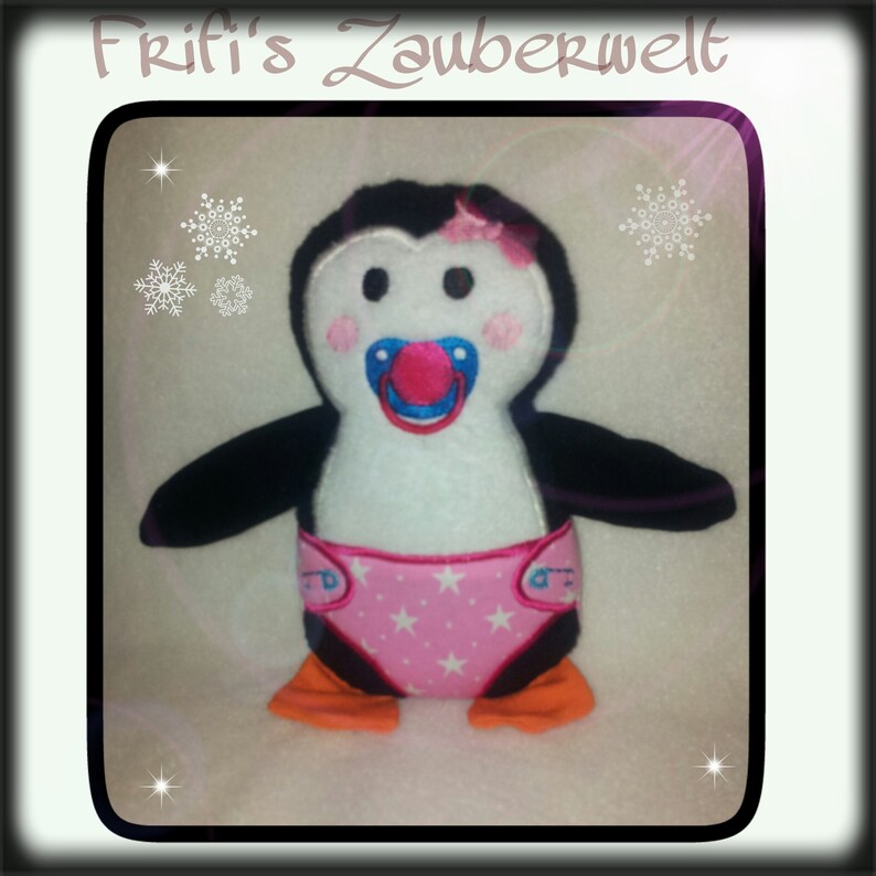 May include: A plush penguin toy with a pacifier, wearing a pink diaper with white stars. The penguin has black wings, orange feet, and a pink bow. The text "Frifi's Zauberwelt" is at the top.
