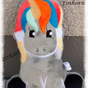 May include: A plush unicorn toy with a gray body, black hooves, and a colorful mane and tail. The mane features red, orange, blue, and green hues. The text "ITH Einhorn" and "20x30" are visible. The text "von Faden-Zauber" is also present.