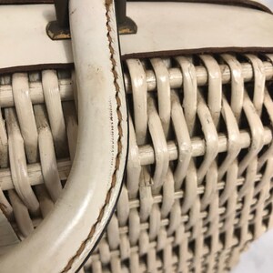 Puede incluir: Cesta de mimbre blanca con asa de cuero blanco. El asa est&aacute; cosida con hilo marr&oacute;n.