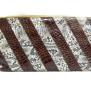 May include: A brown and white snakeskin clutch purse with a gold clasp.