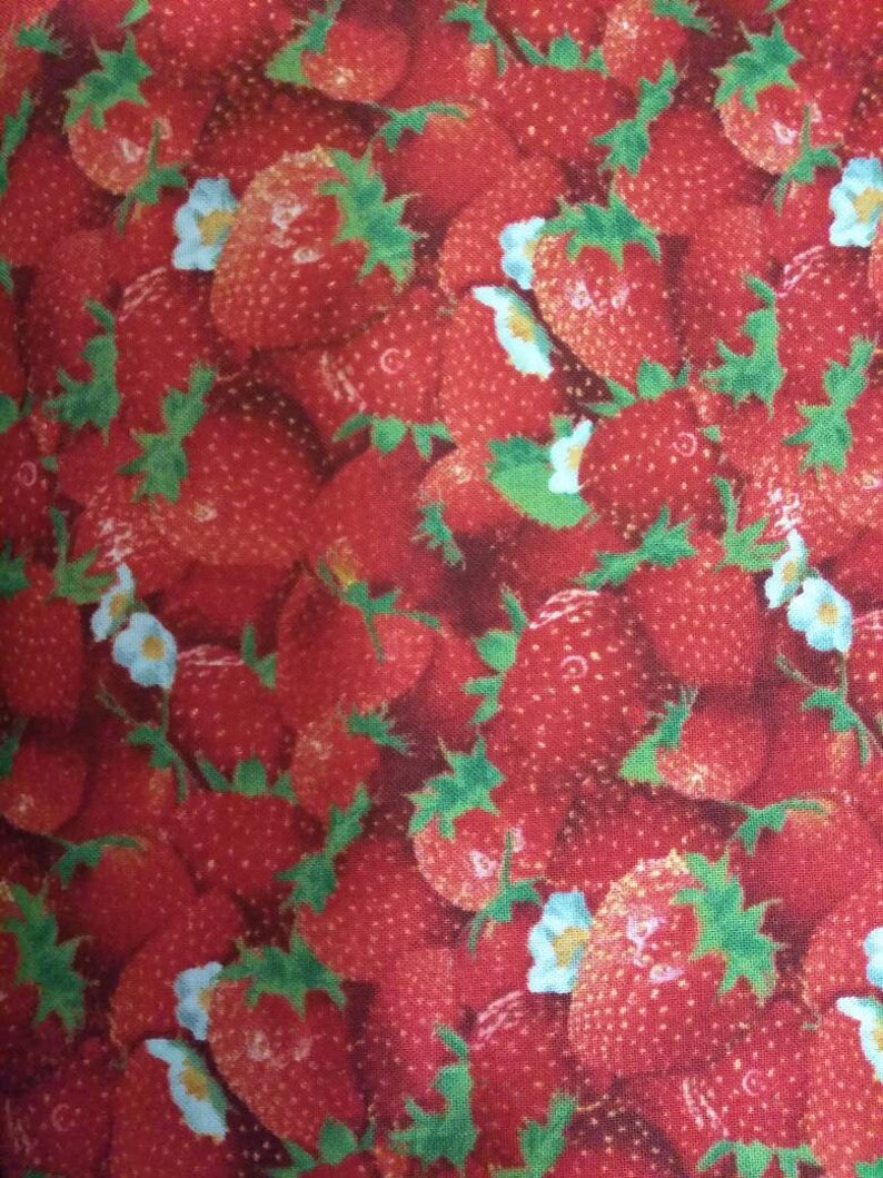 May include: A red fabric with a repeating pattern of strawberries and white flowers. The strawberries are red and green and the flowers are white with a light blue center.