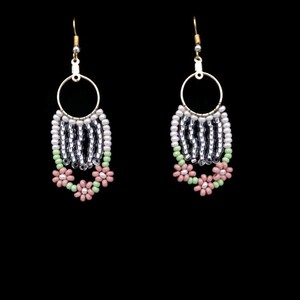 May include: A pair of dangle earrings with a silver and white beaded fringe and pink and green flower accents.