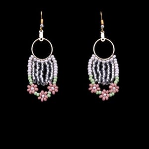 May include: A pair of dangle earrings with silver and white beads, and pink and green flower accents.