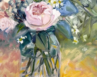May include: A bouquet of pink and white flowers in a clear glass jar. The flowers are arranged in a loose, natural style, and the jar is sitting on a yellow surface.