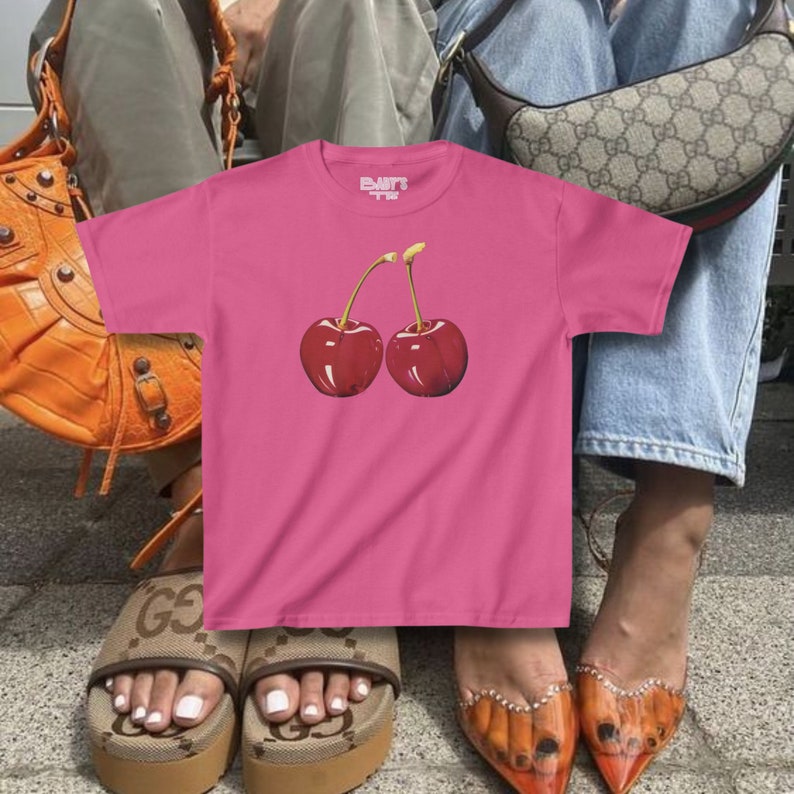 model wears awomens baby tee shirt displaying a y2k cherry